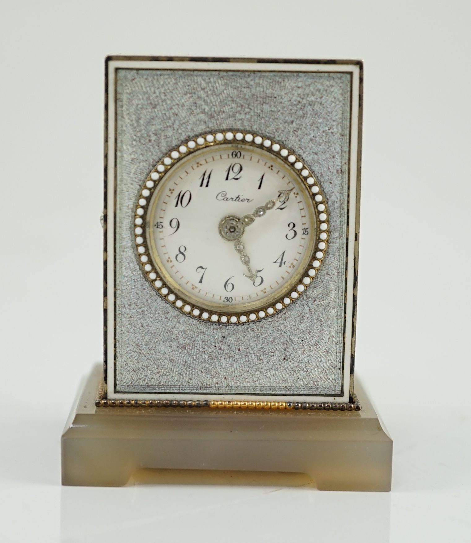 A fine Belle Époque Cartier silver, gold, diamond and guilloche enamel mounted 'Mignonette' timepiece, on an agate plinth base